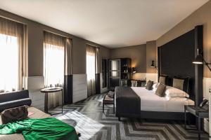 um quarto de hotel com uma cama e um sofá em The Tribune, part of JdV by Hyatt em Roma