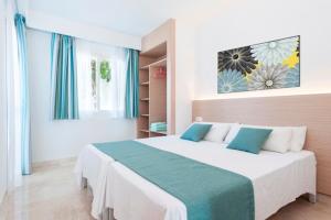 a bedroom with a large bed in a room at Apartamentos Solecito in Port d'Alcudia +21 photos