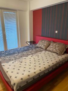 1 dormitorio con 1 cama grande y cabecero rojo en Apartment Alex, en Ohrid