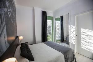 a bedroom with a bed and a large window at Hotel Barrio Nuevo in Lebrija