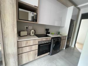 cocina con lavadora y fregadero en Zimbali Boulevard Suites 159 en Ballito