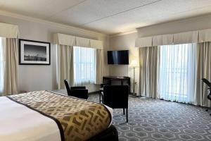 a hotel room with a bed and a desk and chairs at Wyndham Chicago South Loop in Chicago