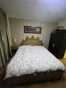 a bedroom with a bed with a white comforter at Apartment in Shmaisani in Amman