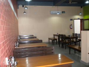 a dining room with wooden tables and chairs at Rains Inn Eco Hotel in Diphu