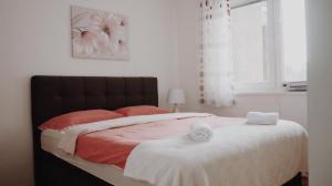 a bedroom with a bed with two towels on it at Apartman Miškec in Kupres