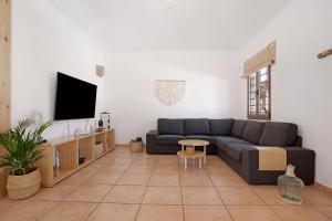un soggiorno con divano e TV di Villa Baobab a Corralejo