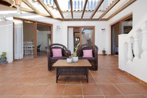 un soggiorno con tavolo e sedie in vimini di Villa Baobab a Corralejo