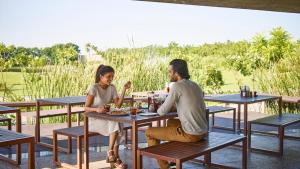 un hombre y una chica sentados en una mesa en Life At REPOSE- Lake Villas Resort & Club, en Chor Warodra