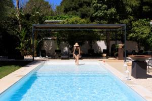 Una donna in bikini che entra in piscina di Domìa Boutique Hotel e Cucina a Mondello