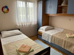 1 dormitorio con 2 camas y ventana en Mira en Barbat na Rabu