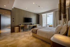 Un dormitorio con una cama, un escritorio y un televisor. en FIVE Palm Jumeirah 2BR Luxury Penthouse , Full Marina See View with Private Pool, en Dubái