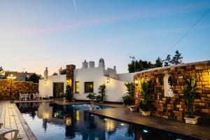 a house with a swimming pool in front of a building at Ocean Suites in San Antonio Bay