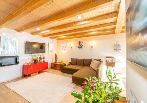 a living room with a couch and a tv at Ocean Breeze in Colares