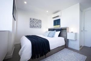 a bedroom with a large bed with a black blanket on it at Spring Hill - beautiful apartment in Brisbane