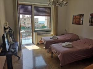 una camera d'albergo con due letti e una finestra di Casa di Linda a Salerno