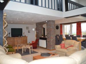 a living room with a couch and a tv at Vacation home in Verviers with private indoor pool in Verviers