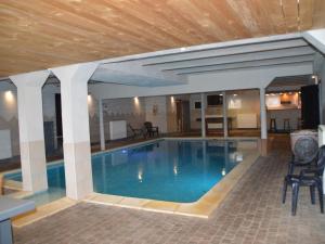 a large swimming pool with a wooden ceiling at Vacation home in Verviers with private indoor pool in Verviers