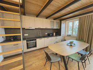 a kitchen with a table and chairs in a room at Gmunder Premium Dachgeschoss-Apartments in Gmund am Tegernsee