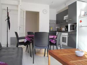 eine Küche mit Stühlen und einem Tisch im Zimmer in der Unterkunft Charmante maisonnette à Fort-Mahon-Plage, près de la Baie d'Authie, 2 chambres, jardin, parking inclus - FR-1-482-38 in Fort-Mahon-Plage