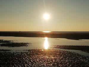 einen Sonnenuntergang am Strand mit der Sonne, die im Wasser reflektiert in der Unterkunft Charmante maisonnette à Fort-Mahon-Plage, près de la Baie d'Authie, 2 chambres, jardin, parking inclus - FR-1-482-38 in Fort-Mahon-Plage + 5 Fotos