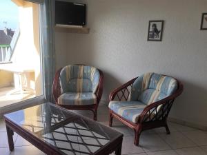 dwa krzesła i stolik kawowy w salonie w obiekcie Appartement Fort-Mahon-Plage, 3 pièces, 4 personnes - FR-1-482-5 w mieście Fort-Mahon-Plage