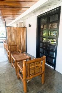 rząd drewnianych ławek siedzących obok drzwi w obiekcie OKEANOS HOTEL w mieście Moalboal