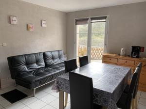 un salon avec une table et un canapé en cuir dans l'établissement Maison à 50m de la Plage avec Terrasse, 2 Chambres et Parking Privé - Fort-Mahon-Plage - FR-1-482-35, à Fort-Mahon-Plage
