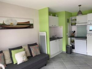 a living room with a couch and a kitchen at Appartement Fort-Mahon-Plage, 2 pièces, 4 personnes - FR-1-482-15 in Fort-Mahon-Plage