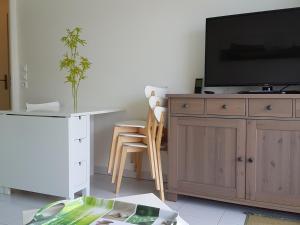 un salon avec une télévision sur un meuble en bois dans l'établissement Fort-Mahon : Superbe T2 à 2 pas de la plage avec parking privé - FR-1-482-15, à Fort-Mahon-Plage