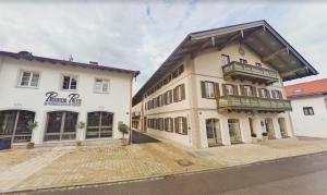 a large white building with a balcony on a street at Gmunder Premium Dachgeschoss-Apartments in Gmund am Tegernsee