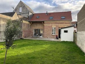 a brick house with a lawn in front of it at Maison de pêcheur+ jardin 5 min à pieds de la Baie in Le Crotoy