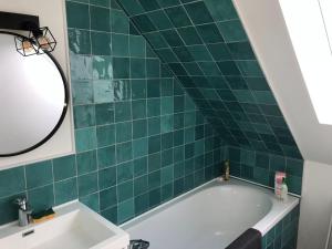 勒克羅圖瓦的住宿－Maison de pêcheur+ jardin 5 min à pieds de la Baie，绿色瓷砖浴室设有浴缸和水槽