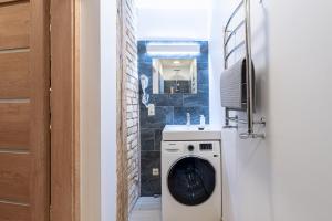- un lave-linge et un sèche-linge dans une salle de bains située à côté d'une porte dans l'établissement Dandelion Apartments Bruņinieku, à Riga