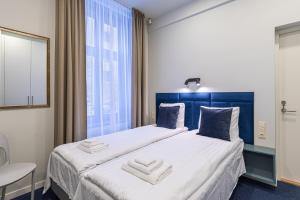 - une chambre avec un lit doté d'une tête de lit bleue et d'une fenêtre dans l'établissement Dandelion Apartments Bruņinieku, à Riga