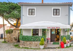 una casa blanca con un cartel que dice fabricante de tambores de café en Ocean Breeze, en Colares