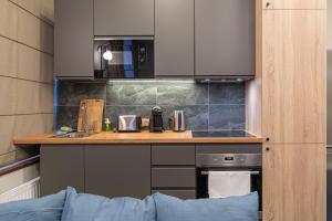 - une cuisine avec un comptoir et un four micro-ondes dans l'établissement Dandelion Apartments Bruņinieku, à Riga