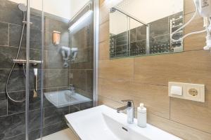 La salle de bains est pourvue d'un lavabo et d'une douche. dans l'établissement Dandelion Apartments Bruņinieku, à Riga