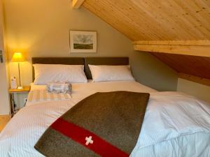 - une chambre avec un grand lit et un plafond en bois dans l'établissement Unique Sustainabel Lodge in the Swiss Jura Mountains, à Neuchâtel