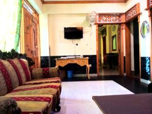 sala de estar con sofá y TV en Bhurban View Apartments, en Murree