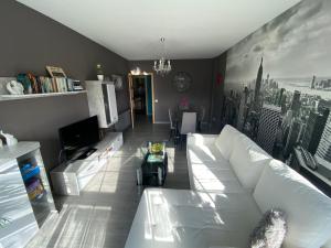 sala de estar con sofá blanco y TV en Precioso piso en el centro de Galicia. en Silleda