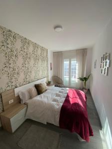 1 dormitorio con 1 cama grande con manta roja en Precioso piso en el centro de Galicia. en Silleda