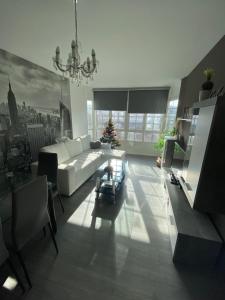 Precioso piso en el centro de Galicia. في سييدا: غرفة معيشة بها أريكة بيضاء و شجرة عيد الميلاد