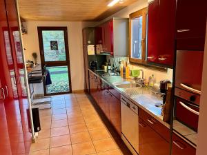 a kitchen with red cabinets and a counter top at Unique Sustainabel Lodge in the Swiss Jura Mountains in Neuchâtel