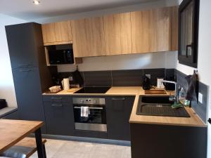 a kitchen with black appliances and wooden cabinets at Domaine de Pacciolello - Porticcio in Porticcio