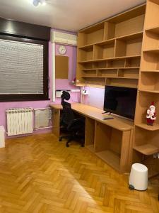 una oficina con escritorio, ordenador y estanterías en Self check-in studio with Wi-Fi and parking place en Zagreb