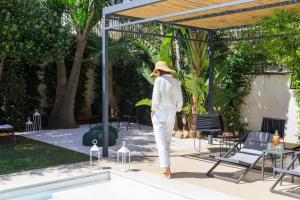 a mannequin in a hat standing next to a pool at Domìa Boutique Hotel e Cucina in Mondello