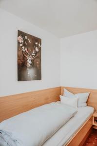 a bedroom with a bed with a picture on the wall at Gasthaus Hirsch in Wangen im Allgäu