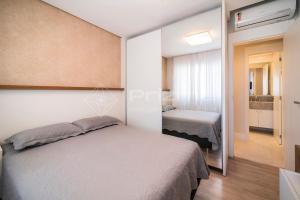 Schlafzimmer mit einem Bett und einem Spiegel in der Unterkunft Varandas 405 A · Apartamento em Condomínio de luxo frente ao mar . in Bombinhas
