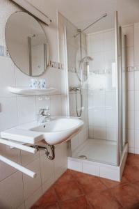 a white bathroom with a sink and a shower at Gasthaus Hirsch in Wangen im Allgäu