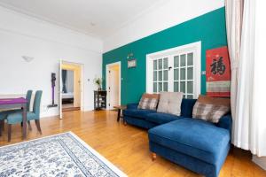 倫敦的住宿－Central 2 Bedroom Apartment near Old Street，客厅配有蓝色的沙发和桌子